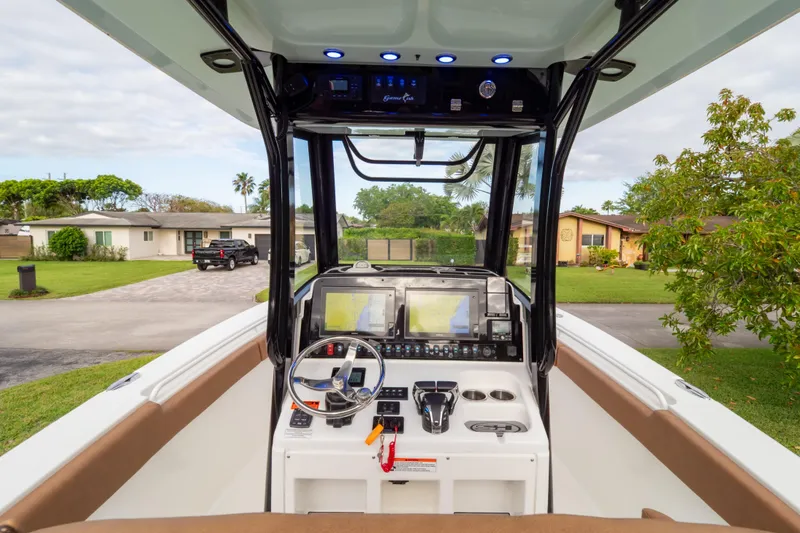 Slide: The Image of 2021 Sea Hunt Gamefish 27 boat console with advanced navigation and controls, parked in a residential area. - 55