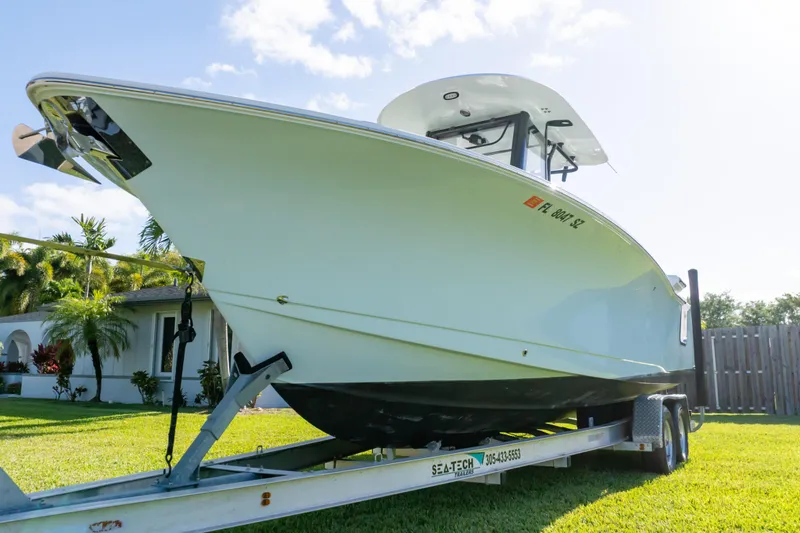 Slide: The Image of 2021 Sea Hunt Gamefish 27 boat on trailer, parked on grass. - 67