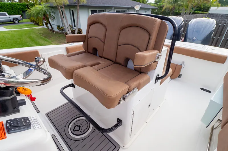 Slide: The Image of 2021 Sea Hunt Gamefish 27 Forward Seating with dual brown captain's chairs and steering wheel. - 7