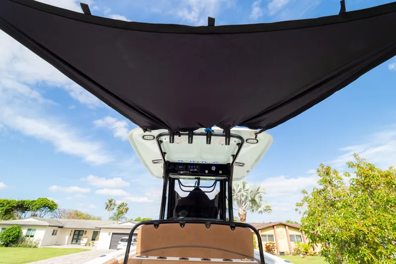 Slide: The Image of 2021 Sea Hunt Gamefish 27 boat with canopy, set against a suburban backdrop. - 87