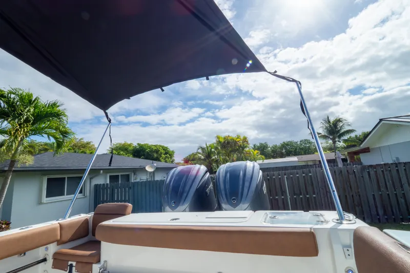 Slide: The Image of 2021 Sea Hunt Gamefish 27 boat with forward seating and canopy under blue sky. - 88