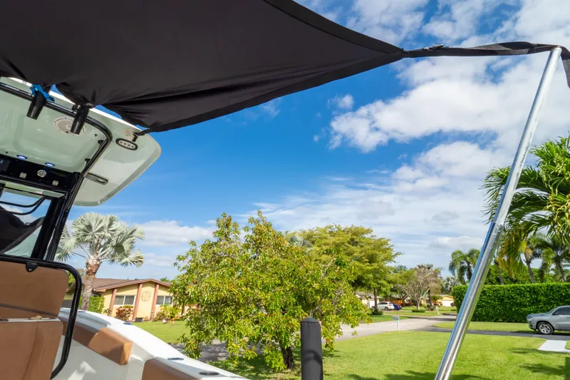 Slide: The Image of 2021 Sea Hunt Gamefish 27 with sunshade, Florida registration, under a blue sky. - 89