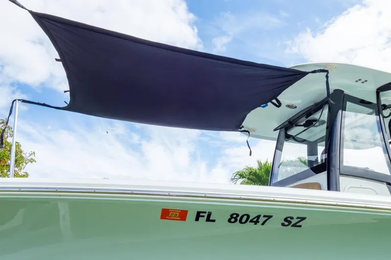 Slide: The Image of 2021 Sea Hunt Gamefish 27 boat with brown forward seating under a clear sky. - 91