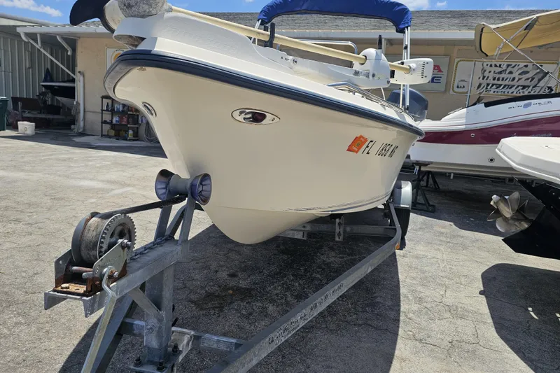 Slide: The Image of 2003 Key West 1720 Sportsman boat on trailer in sunny outdoor setting. - 8