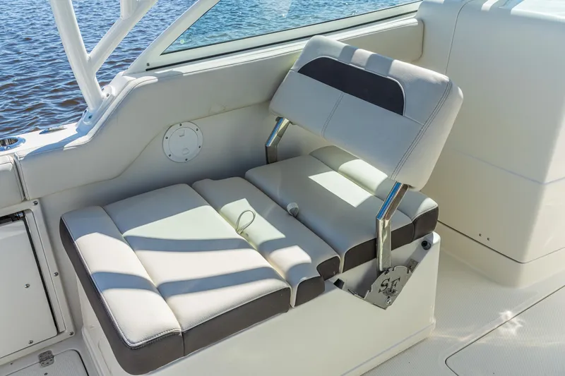 Slide: The Image of Sailfish 245 DC 2027 boat interior with cushioned seating and water view. - 10