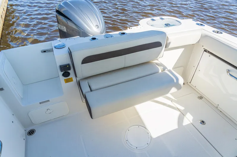 Slide: The Image of 2027 Sailfish 245 DC boat interior with cushioned seating and Yamaha outboard motor. - 13