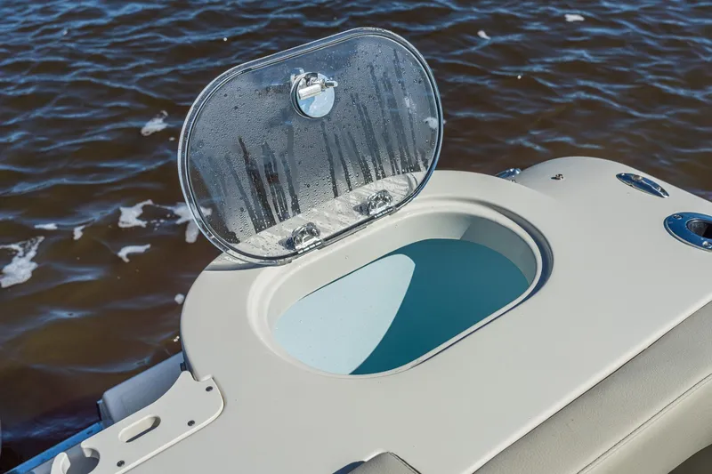 Slide: The Image of Open hatch on 2027 Sailfish 245 DC boat, revealing storage compartment by the water. - 15