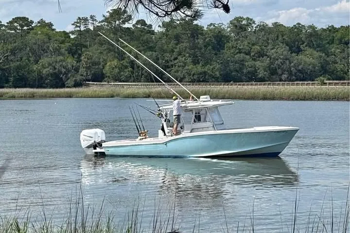 Slide: The Image of Ocean Master 31 boat from 1999 on a calm river with fishing gear. - 2