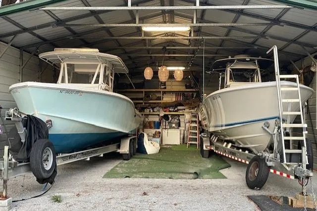 Slide: The Image of Two Ocean Master 31 boats from 1999 stored in a garage on trailers. - 4