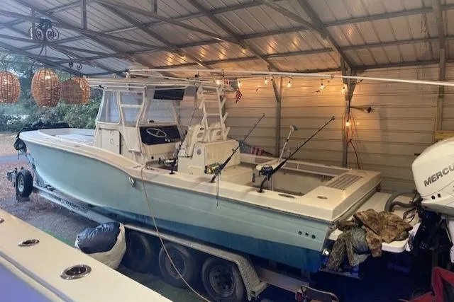 Slide: The Image of 1999 Ocean Master 31 boat in covered storage with fishing rods and Mercury outboard. - 6