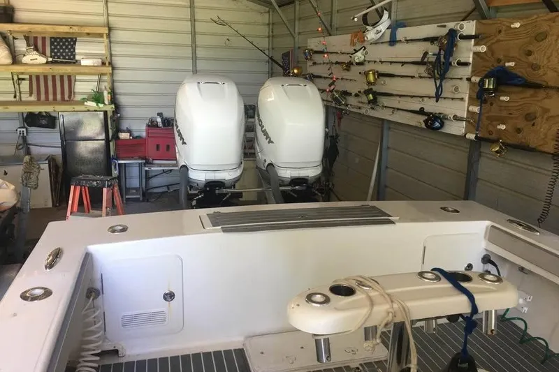 Slide: The Image of 1999 Ocean Master 31 boat with dual outboard engines in a garage setting. - 8