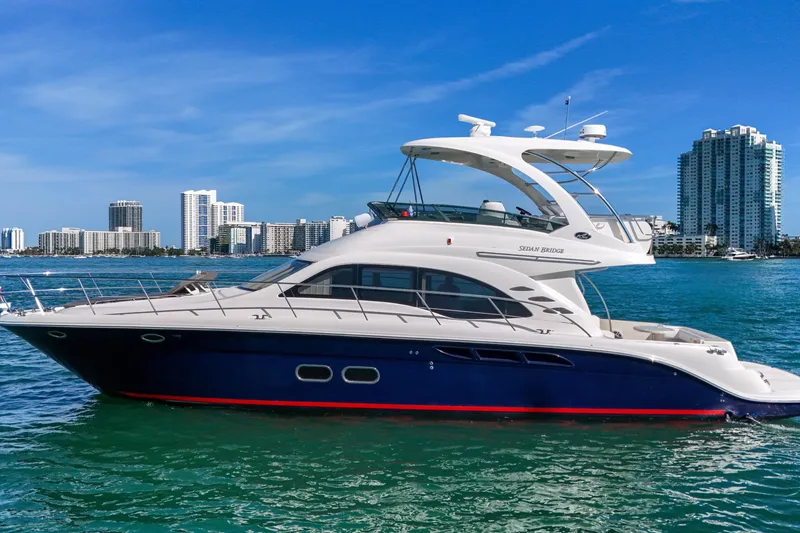 The Image of 2007 Sea Ray 52 Sedan Bridge yacht cruising near city skyline. - 0