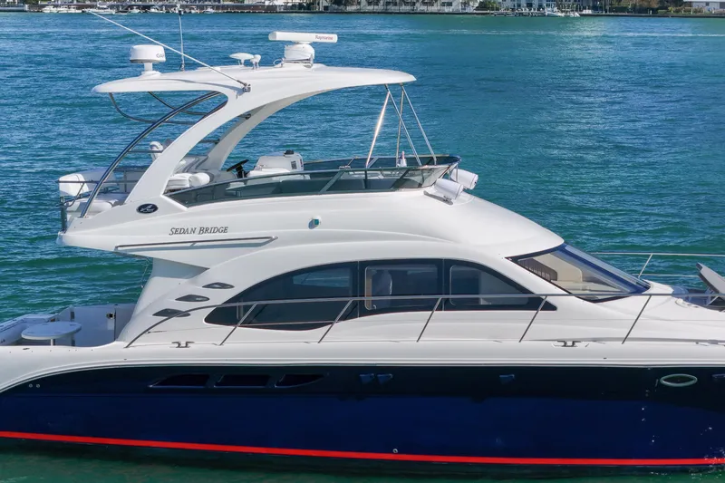 Slide: The Image of 2007 Sea Ray 52 Sedan Bridge yacht cruising on clear blue water. - 12