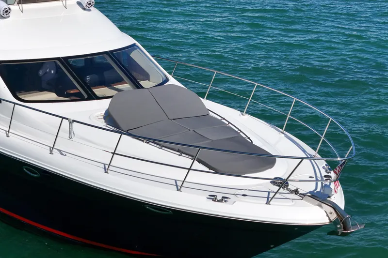 Slide: The Image of 2007 Sea Ray 52 Sedan Bridge yacht on clear blue water, featuring sleek design and sunbathing area. - 14