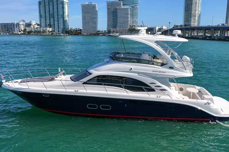 Slide: The Image of 2007 Sea Ray 52 Sedan Bridge yacht cruising near modern city skyline. - 16