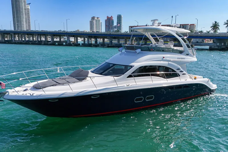 Slide: The Image of 2007 Sea Ray 52 Sedan Bridge yacht cruising near a city bridge. - 17