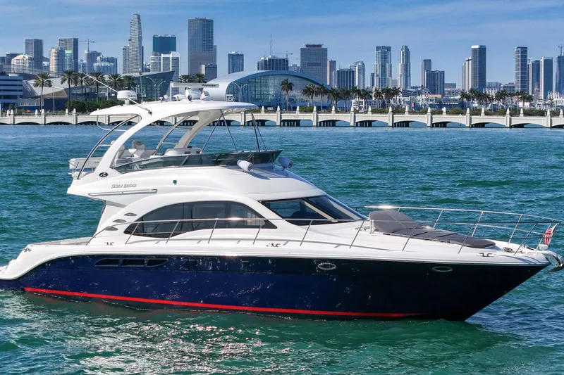 Slide: The Image of 2007 Sea Ray 52 Sedan Bridge yacht cruising near a city skyline on a sunny day. - 20