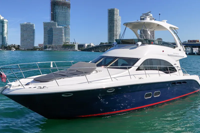 Slide: The Image of 2007 Sea Ray 52 Sedan Bridge yacht cruising near modern city skyline. - 3
