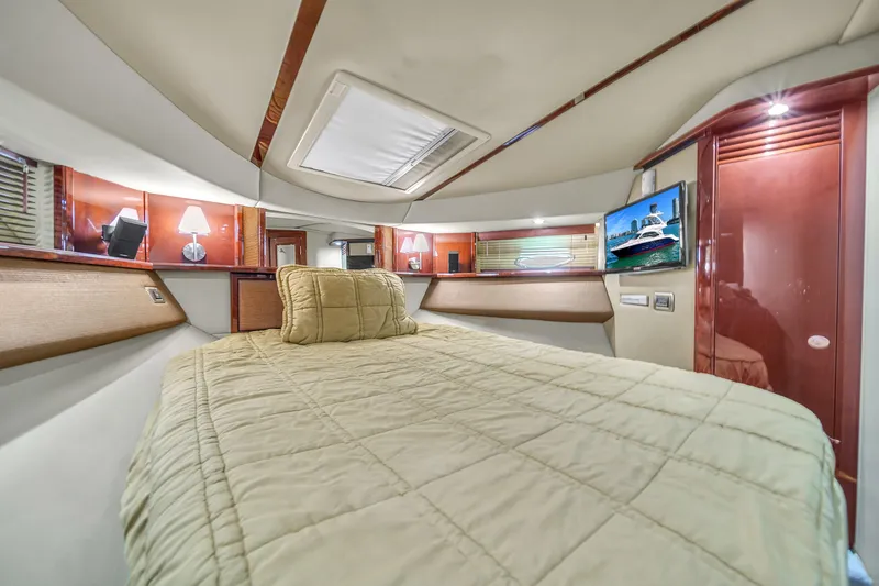 Slide: The Image of Luxurious 2007 Sea Ray 52 Sedan Bridge cabin interior with cozy bedding and elegant wood finishes. - 30