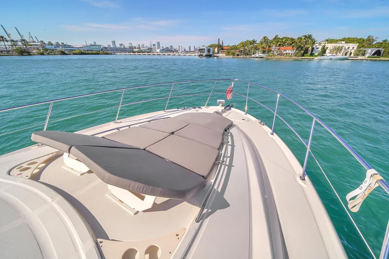 Slide: The Image of 2007 Sea Ray 52 Sedan Bridge yacht with sunpad, cruising near a scenic coastline. - 55