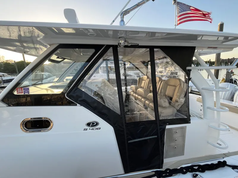 Slide: The Image of 2019 Pursuit S 408 Sport boat with enclosed seating area and American flag. - 15