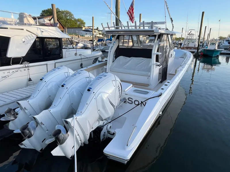 Slide: The Image of 2019 Pursuit S 408 Sport boat docked with triple outboard engines. - 17