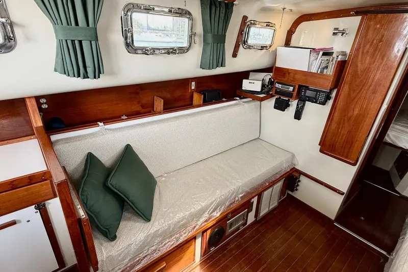 Slide: The Image of Interior of a 1975 Soverel 37 sailboat with wooden accents and green curtains. - 12