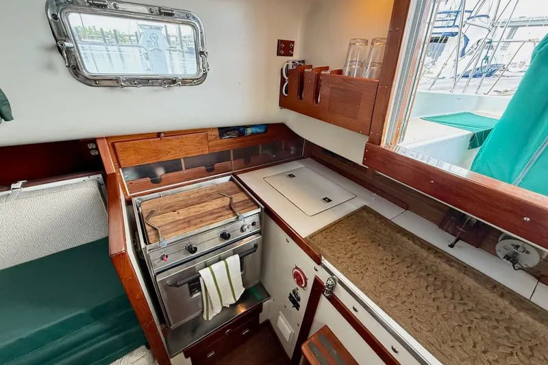 Slide: The Image of Cozy 1975 Soverel 37 yacht kitchen with stove, wooden cabinetry, and window view. - 17