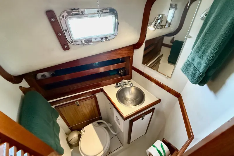 Slide: The Image of Compact bathroom in a 1975 Soverel 37 sailboat with sink, toilet, and wooden accents. - 20