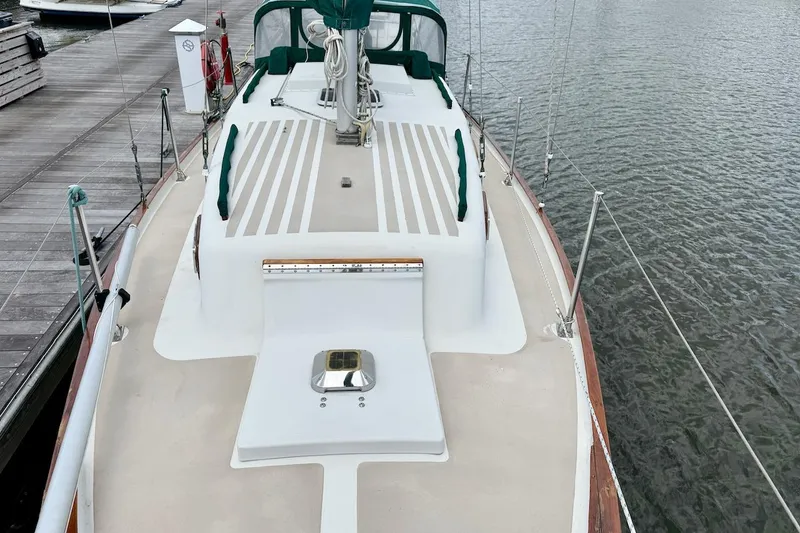 Slide: The Image of 1975 Soverel 37 sailboat docked, featuring a clean deck and green accents. - 6