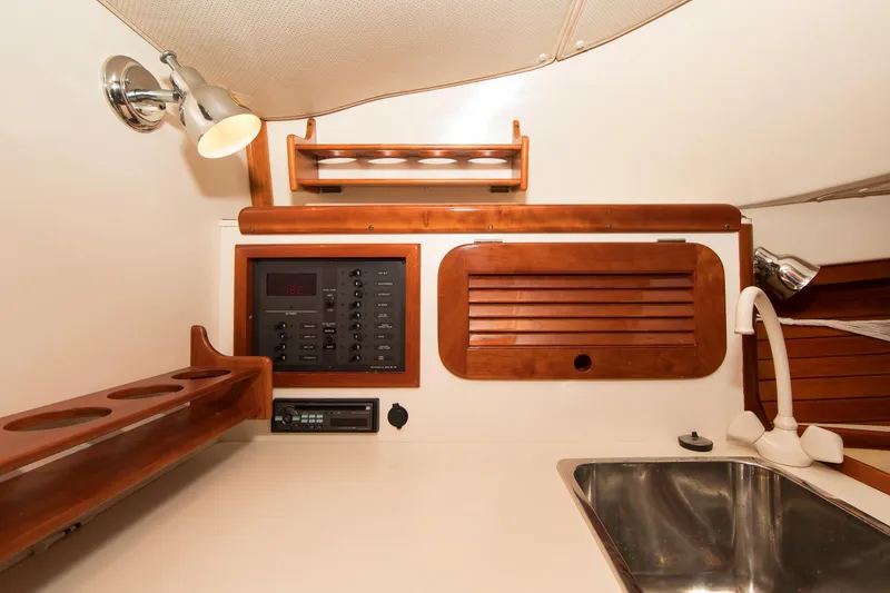 Slide: The Image of Interior of 1997 Hinckley Runabout 29 featuring wooden cabinetry and a stainless steel sink. - 11
