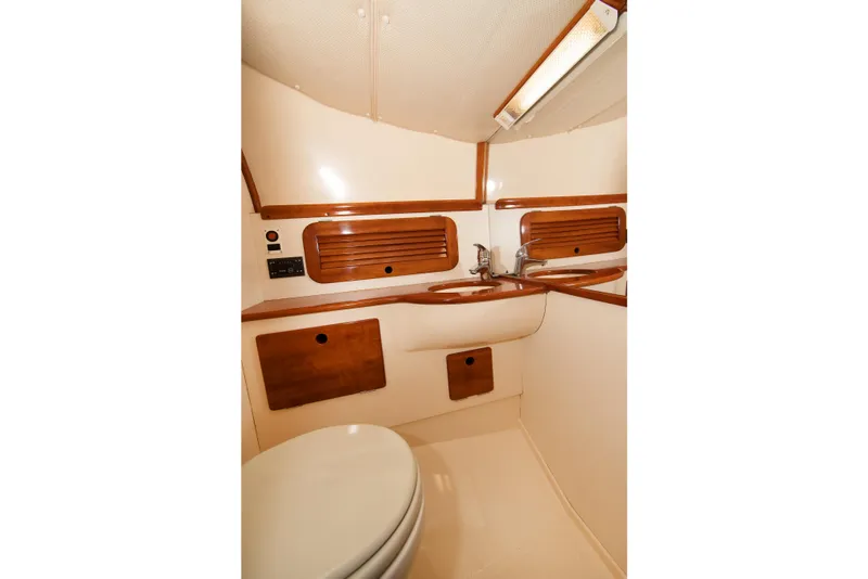 Slide: The Image of Hinckley Runabout 29 (1997) boat bathroom with wooden accents and compact design. - 14