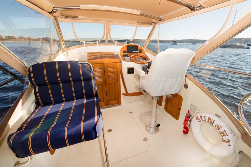 Slide: The Image of Interior of a 1997 Hinckley Runabout 29 boat with striped seating and steering console. - 2