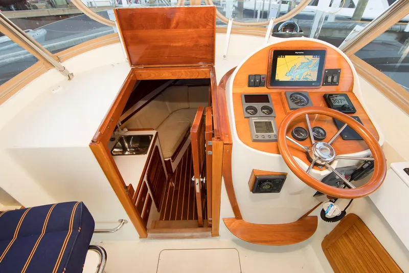 Slide: The Image of Interior view of a 1997 Hinckley Runabout 29, featuring a wooden helm and navigation equipment. - 3