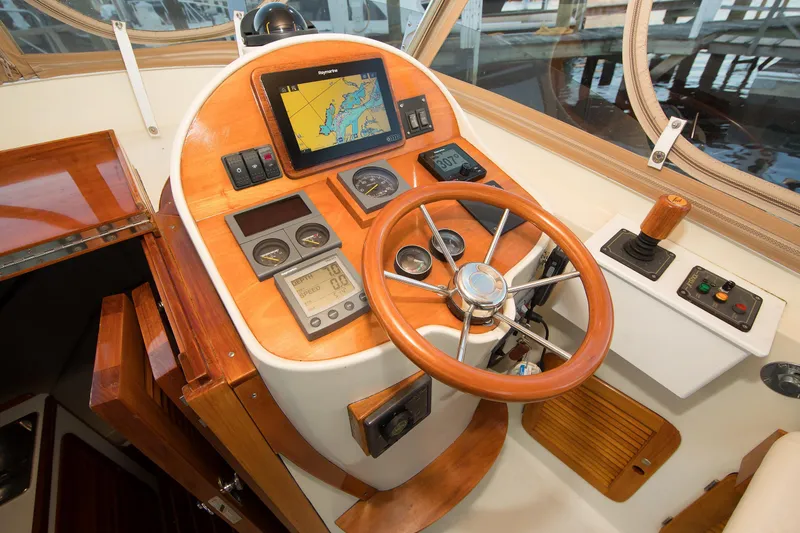 Slide: The Image of 1997 Hinckley Runabout 29 boat dashboard with wooden steering wheel and navigation instruments. - 8