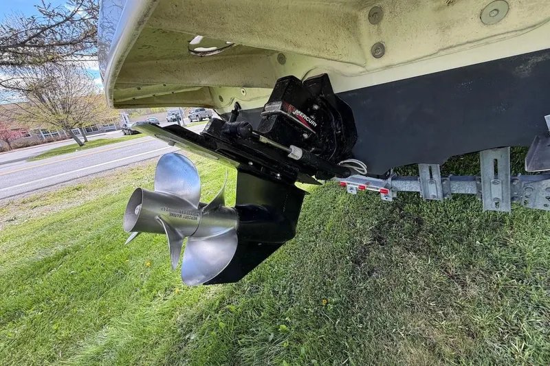 Slide: The Image of 2002 Sea Ray 240 Sundancer boat propeller and stern drive on grassy area. - 11