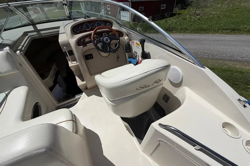 Slide: The Image of 2002 Sea Ray 240 Sundancer boat interior with steering wheel and seating area. - 14