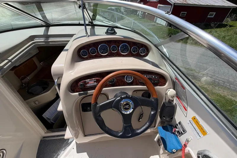 Slide: The Image of Helm of 2002 Sea Ray 240 Sundancer with wood-accented dashboard and steering wheel. - 15