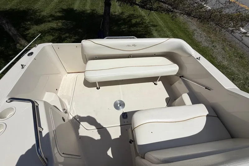 Slide: The Image of 2002 Sea Ray 240 Sundancer boat interior with white seating and clean deck. - 18