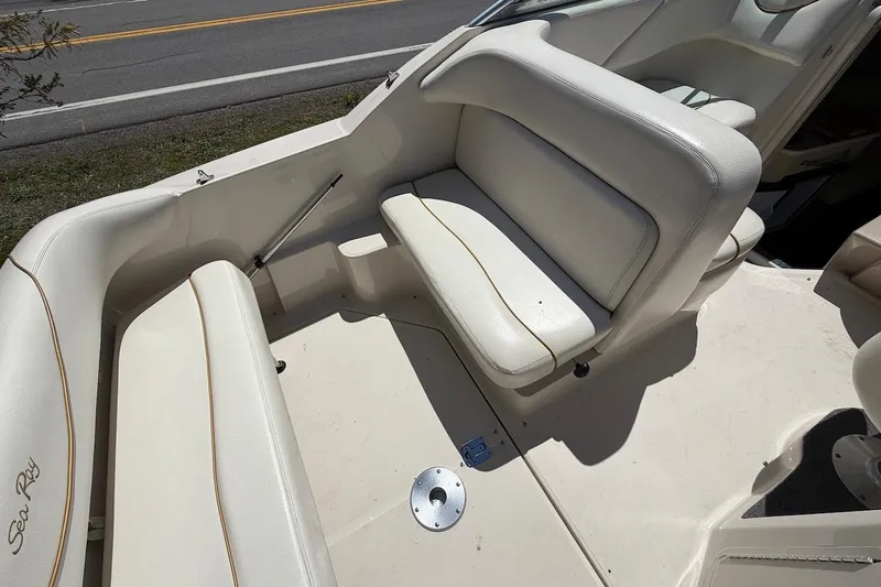 Slide: The Image of 2002 Sea Ray 240 Sundancer boat interior with white seating and clean deck. - 19