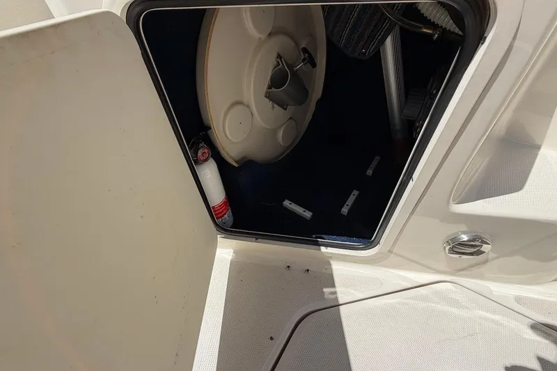 Slide: The Image of Open hatch on 2002 Sea Ray 240 Sundancer boat, revealing interior storage space. - 22