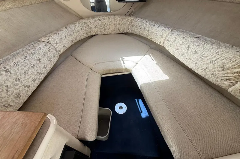 Slide: The Image of Interior cabin of 2002 Sea Ray 240 Sundancer with beige upholstery and patterned cushions. - 24