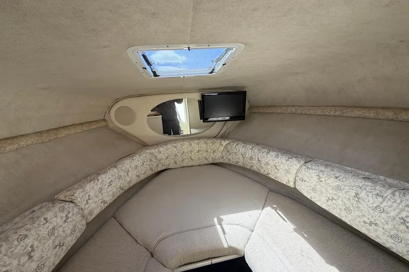Slide: The Image of Interior cabin of 2002 Sea Ray 240 Sundancer with cozy seating and a small TV. - 25