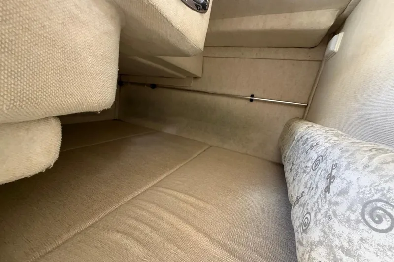 Slide: The Image of Interior cabin view of 2002 Sea Ray 240 Sundancer, featuring beige upholstery and compact design. - 29