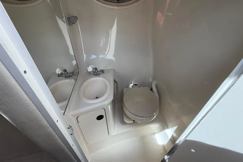 Slide: The Image of 2002 Sea Ray 240 Sundancer boat bathroom with sink and toilet. - 30