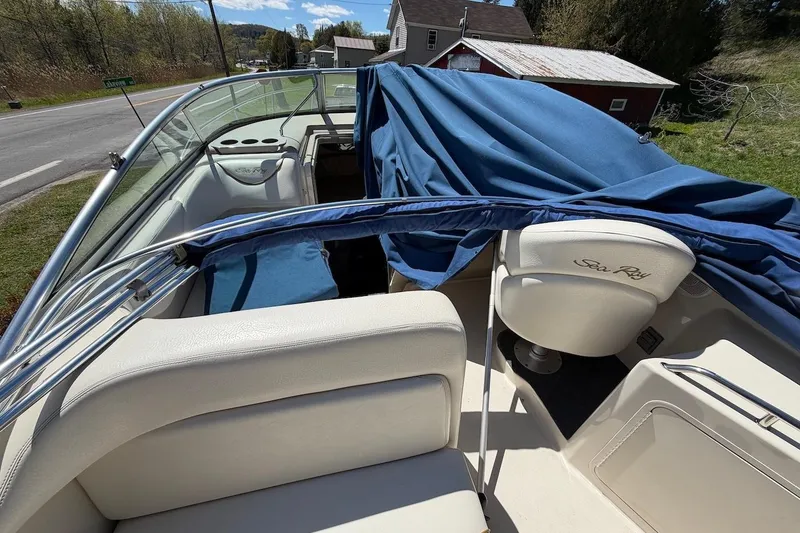 Slide: The Image of 2002 Sea Ray 240 Sundancer boat interior with blue cover and white seating. - 41