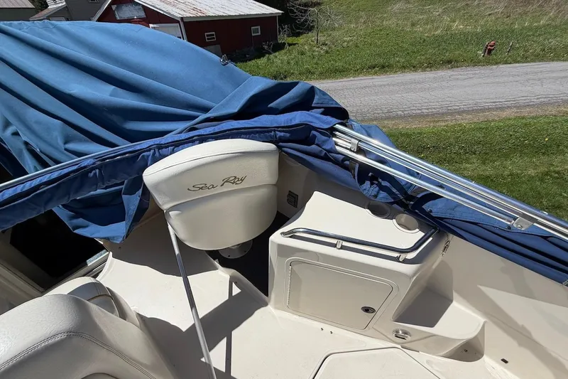 Slide: The Image of 2002 Sea Ray 240 Sundancer boat interior with blue cover and white seating. - 42