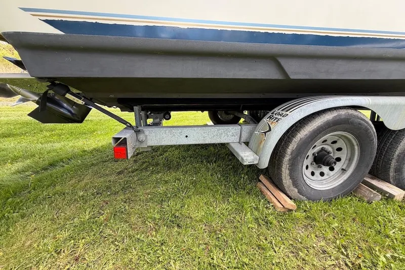Slide: The Image of Trailer with 2002 Sea Ray 240 Sundancer boat on grass, showcasing rear view and wheels. - 6