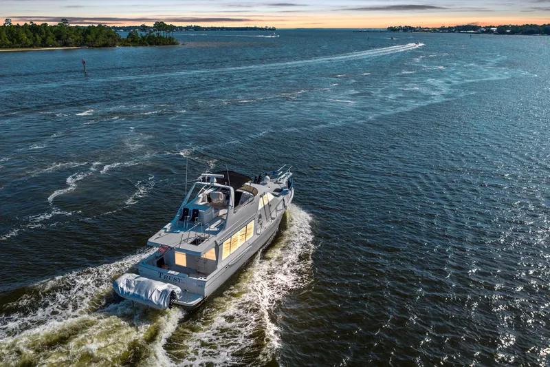Slide: The Image of 2007 Meridian 490 Pilothouse yacht cruising on a serene waterway at sunset. - 1
