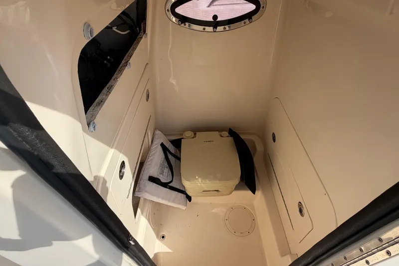 Slide: The Image of 2018 Grady-White Fisherman 236 boat interior with portable toilet and storage compartments. - 17